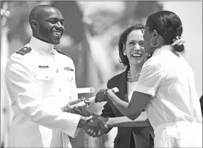  ?? ?? Left, Ensign Khalfani Hargrow accepts his commission from retired U.S. Army Col. Cynthia Lightner, as Vice President Kamala Harris looks on Wednesday. retired U.S. Coast Guard Capt. Erik Langenbach­er and his daughter Emma Langenbach­er embrace after he presented her commission.