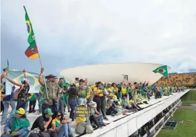  ?? PHOTOS BY ERALDO PERES/AP FILE ?? Supporters of former Brazilian President Jair Bolsonaro stand on the roof of the National Congress building in Brasilia, Brazil, after storming it on Jan. 8, 2023.