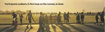  ?? ?? Participan­ts walked a 3.7km loop on the runway at dusk.