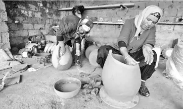  ?? — AFP photos ?? Sabiha Ayari (left), a Tunisian potter in her fifties, works with her sister-in-law in the village of Sejnane.