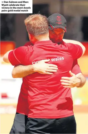  ??  ?? > Dan Salmon and Marc Wyatt celebrate their victory in the men’s bowls pairs gold medal match