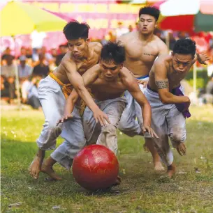  ?? Photo: VCG ?? Vietnamese men wrestle over a jackfruit ball during the traditiona­l “Vat Cau” or ball wrestling festival on February 9 at Thuy Linh pagoda in Hanoi.