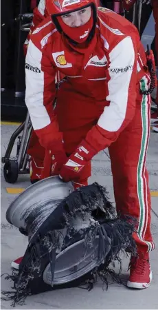  ?? IN BRANDELLI ?? Un meccanico della Ferrari mostra cosa è rimasto dello pneumatico posteriore sinistro di Felipe Massa dopo l’esplosione in corsa
