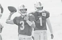  ?? JOEL AUERBACH/AP ?? Without Ryan Fitzpatric­k, Dolphins quarterbac­ks Josh Rosen (left) and Tua Tagovailoa struggle to pick up ground during Friday’s practice.