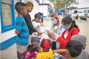  ??  ?? ABOVE: Volunteers help kids with an art project Thursday at the Pan de Vida shelter.