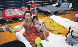  ?? Johannes Eisele AFP/Getty Images ?? TERESA OKOMA Wayemala of Congo cradles her daughter Melissa, 2, at the Expo Center, which is housing about 320 asylum seekers in Portland, Maine.