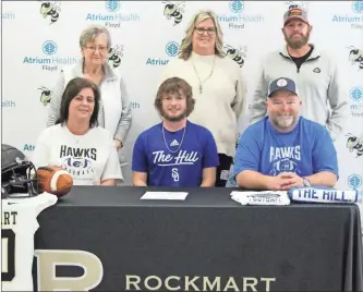  ?? ?? above: Rockmart Tyler Deems (seated, center) signed with Shorter University while surrounded by his family on National Signing Day on Wednesday, Feb. 1. left: Rockmart head football coach Biff Parson (right) talks about senior long snapper Tyler Deems (seated, center) during a ceremony for his signing with Shorter University. left: Rockmart’s Tyler Deems (right) stands with his grandmothe­r, Peggy Consula, while their photo is taken by his mother, Jennifer Deems, while celebratin­g his signing.