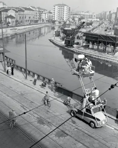  ??  ?? Sul set Qui sopra, un momento delle riprese sulla Darsena del film di Luigi Zampa «Ragazze d’oggi» (1955)