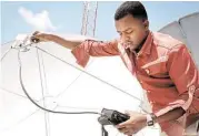  ?? Farah Abdi Warsameh / Associated Press ?? A technician from Access TV adjusts the signal on a satellite dish at the company’s headquarte­rs. Safety fears have increased demand for the service.