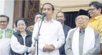  ?? — AFP ?? President Joko Widodo (C) and his running mate Ma’ruf Amin (R) hold a press conference in Jakarta on Thursday.