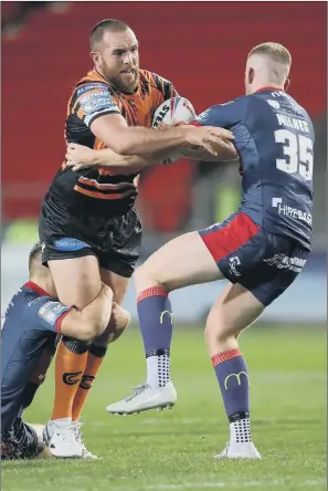  ?? PICTURE: PA ?? SUPER LEAGUE BATTLE: Castleford Tigers’ Daniel Smith is tackled by Hull KR’s Rowan Milnes, right, and Mikey Lewis during last night’s match at the Totally Wicked Stadium.