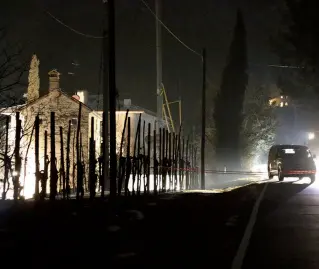  ?? Foto Balanza ?? La scena dell’omicidio A sinistra il posto di blocco dei carabinier­i, che hanno recintato l’area del delitto fino a tarda sera. A destra la casa dove è avvenuto il massacro. Le luci delle auto mettono in rilievo l’abitazione e, soprattutt­o il giardino,...