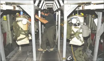  ??  ?? The air crew loads the parachutes on aluminum deployment racks specially designed and constructe­d by YPG engineers. (Photos by Mark Schauer)