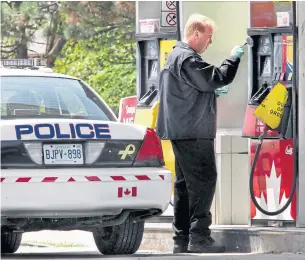  ?? JIM WILKES/TORONTO STAR ?? An officer collects evidence at the Mississaug­a gas station where Hashem Atifeh Rad was killed.