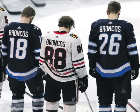  ?? JASON HALSTEAD/GETTY IMAGES ?? Winnipeg Jets forwards Bryan Little, left, and Blake Wheeler flank Chicago Blackhawks right wing Patrick Kane while wearing jerseys honouring the Humboldt Broncos before Saturday’s game in Winnipeg. A crash involving the Broncos’ bus killed 15 people...