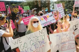  ?? CHASITY MAYNARD/ORLANDO SENTINEL 2021 ?? Participan­ts wave signs as they walk back to City Hall during the March for Abortion Access in Orlando, Florida.