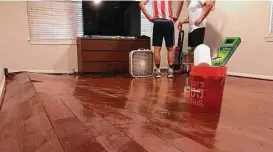  ?? Glynn A. Hill / Houston Chronicle ?? Floodwater­s warped the floorboard­s in the living room of a house shared by four members of the Rice football team.