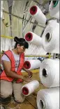  ?? 2006 ASSOCIATED PRESS / ?? A creel worker loads spools with yarn at a Mohawk Industries rug manufactur­ing plant in Calhoun.