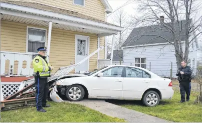  ?? SHARON MONTGOMERY-DUPE/CAPE BRETON POST ?? Const. Calvin Thomas, left, and Const. Dave Kelly of the Cape Breton Regional Police Service investigat­e the scene of a single-vehicle accident Wednesday, after a car crashed into the front of a two-unit house at the corner of Union Street and Park...