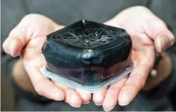  ?? — Reuters ?? A man holds a Canapux crude oil solid pellet from Canadian National Railway Company in Montreal, Quebec, Canada.