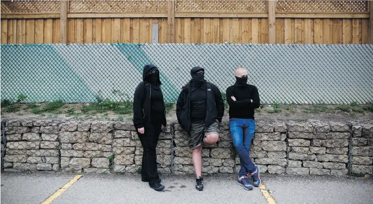  ?? COLE BURSTON FOR THE NATIONAL POST ?? Three masked people stood outside the Richview branch of the Toronto Public Library Wednesday while a memorial for Toronto lawyer Barbara Kulaszka was held.