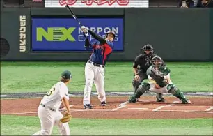  ?? Kenta Harada / Getty Images ?? Japan’s Shohei Ohtani hits a three run home run during the World Baseball Classic Pool B game between Japan and Australia at Tokyo Dome on Sunday.