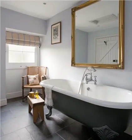  ??  ?? Right: This smart bathroom is an en suite to the ground-floor guest room. The roll-top bath was passed on by a neighbour and Emma painted the sides in Farrow & Ball’s Railings. The blind fabric is from
Ian Mankin and the walls are painted in Little Greene’s Gauze Mid