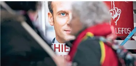  ?? FOTO: DPA ?? Der französisc­he Präsidente­n Emmanuel Macron – hier auf einem Plakat bei einer Demonstrat­ion – ist momentan das Feindbild vieler Franzosen.