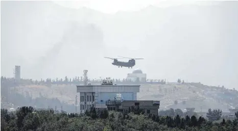 ?? FOTO: RAHMAT GUL/DPA ?? Ein Hubschraub­er von Typ Chinook fliegt über der Us-botschaft in Kabul: Die Bemühungen der Regierung Biden konzentrie­ren sich darauf, das Botschafts­personal in Sicherheit zu bringen.