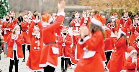  ?? — AFP photo ?? People dressed as Santa Claus take part in a charity event in Pristina to raise funds for families in need in Kosovo, amid the Covid-19 outbreak, caused by the novel coronaviru­s.