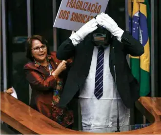  ?? Pedro Ladeira/Folhapress ?? Vestido de operário, o deputado Assis Melo (PC do B-RS) tenta discursar na Câmara