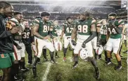  ?? AL DIAZ adiaz@miamiheral­d.com ?? Jalar Holley (98) led teammates in a celebrator­y dance after a UM win over Louisville in 2019.