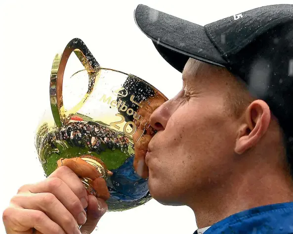  ?? GETTY IMAGES ?? Winning jockey Kerrin McEvoy kisses the Melbourne Cup after his triumph on Cross Counter at Flemington yesterday.