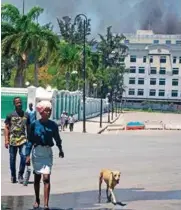  ?? FOTO: ?? AFP
MIEDO. Mientras salía humo de edificio del Ministerio de Finanzas, haitianos huían de zona.