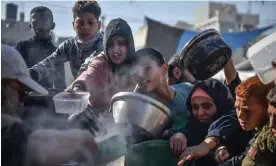  ?? Photograph: Anadolu/Getty Images ?? ‘How do we avoid hunger turning into famine?’ Palestinia­ns receive humanitari­an aid in Rafah, Gaza, on 19 December 2023.