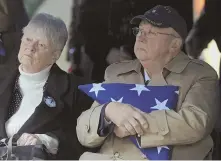  ??  ?? TRIBUTE: Robert Whelihan Sr. holds the flag presented to him at the graveside service for his cousin, Cpl. Jules Hauterman Jr., seen below. South Korean Consul General Ohm Song-jun, bottom, pays his respects.