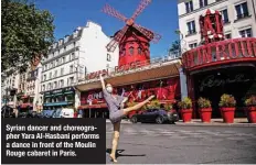  ??  ?? Syrian dancer and choreograp­her Yara Al-Hasbani performs a dance in front of the Moulin Rouge cabaret in Paris.