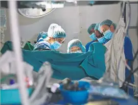  ?? Carl de Souza AFP/Getty Images ?? GYNECOLOGI­CAL surgeon Marci Bowers operates on a woman in Nairobi, Kenya. Bowers spent two weeks there performing restorativ­e surgery on 44 women.