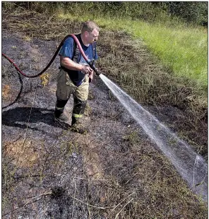  ?? Arkansas Democrat-Gazette/BENJAMIN KRAIN ?? North Pulaski Fire District 15 volunteer Capt. Marcus Steele puts out a brush fire Thursday off Gribble Road in Jacksonvil­le that started after winds blew embers from a tree stump a homeowner was burning into woods behind the home.