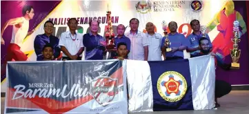  ??  ?? Gerawat (third left) presents the overall championsh­ip trophy to Baram Ulu Zone team captain Jimbun Berandak.