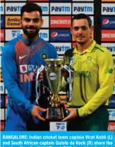  ??  ?? BANGALORE: Indian cricket team captain Virat Kohli (L) and South African captain Quinto de Kock (R) share the trophy after the third Twenty20 internatio­nal cricket match of a three-match series between India and South Africa ended with a draw, at the M. Chinnaswam­y Stadium in Bangalore yesterday. — AFP