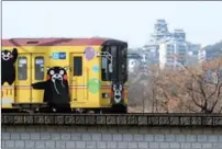  ?? TOSHIRO KUBO / THE YOMIURI SHIMBUN ?? A train decorated with Kumamon the bear, who represents the prefecture, passes Kumamoto Castle on March 3.