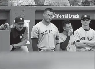  ?? MICHAEL DWYER/AP PHOTO ?? Yankees manager Aaron Boone, left, and Giancarlo Stanton, second from left, watch from the dugout during the ninth inning of Saturday’s game against the Red Sox at Boston.