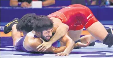  ?? REUTERS ?? Bajrang Bajrang (in blue) gets pinned by Japan's Takuto Otoguro in the men's freestyle 65kg gold medal bout in Budapest on Monday.