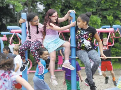  ?? Carol Kaliff / Hearst Connecticu­t Media ?? From left, Rebecca Araujl, Alexis Garcia, both 8, and Jahnaiya Reyes, 9, chat on the bars on the playground during recess on June 6. Parents and teachers at Pembroke Elementary are trying to raise $150,000 for a new playground and park at the school that would be more accessible to the school’s 90 special needs students.