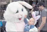  ??  ?? Oliver Stuart, 9 months old, of Sunnyvale, laughs at the big bunny while having his photo taken by his parents at the 20th annual Bunnies and Bonnets parade in Campbell.