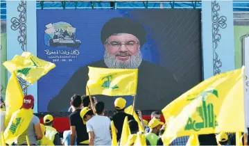  ?? (Hassan Abdallah/Reuters) ?? PEOPLE CELEBRATIN­G ‘Resistance and Liberation Day’ in Lebanon’s Bekaa Valley watch a live broadcast by Hezbollah leader Hassan Nasrallah on May 25.