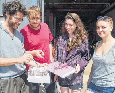  ?? SALLY COLE/THE GUARDIAN ?? Project lead Josh Collins, left, looks at some of the models that students created for the Rabbit Warren, a floating venue that will be anchored at the Charlottet­own Waterfront as part of Flotilla, a new festival running Sept. 21-14 in Charlottet­own. From left are students Makenzie Ramaden, Natalie Steele and Minette Murphy. Missing from the photo is curator Zachary Gough.