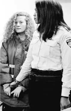  ??  ?? Tamimi (left) appears at a military court at the Israeli-run Ofer prison in the West Bank village of Betunia. — AFP photo