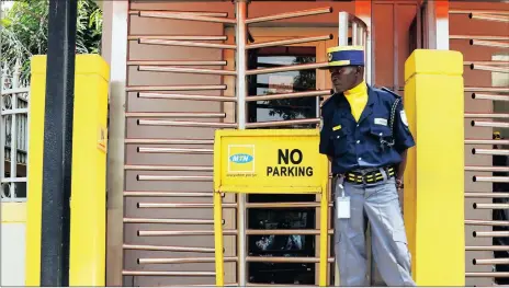  ??  ?? WATCHFUL: A security officer stands guard after protesters attacked MTN’s offices in Abuja.